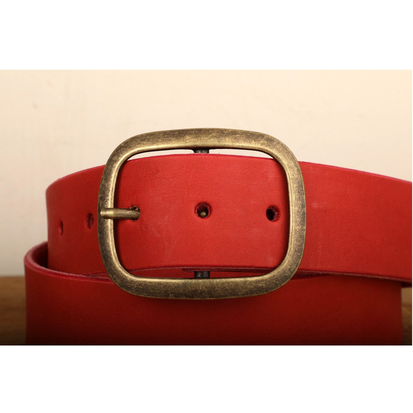a close up of a red belt with a gold buckle