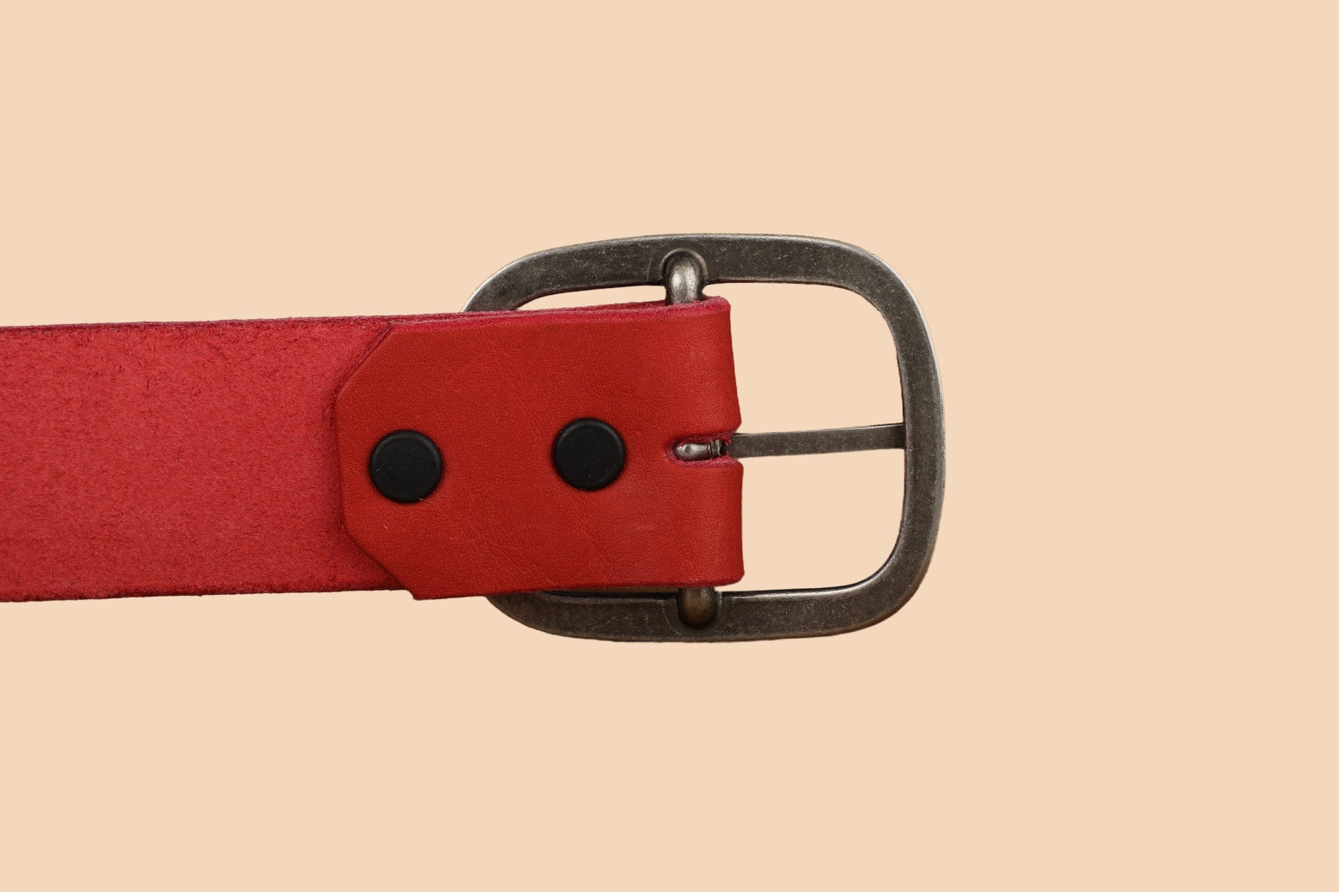 a red belt with a metal buckle on a beige background