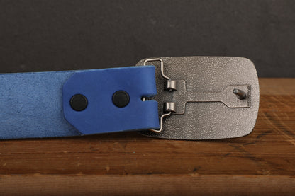 a pair of blue and silver belts sitting on top of a wooden table