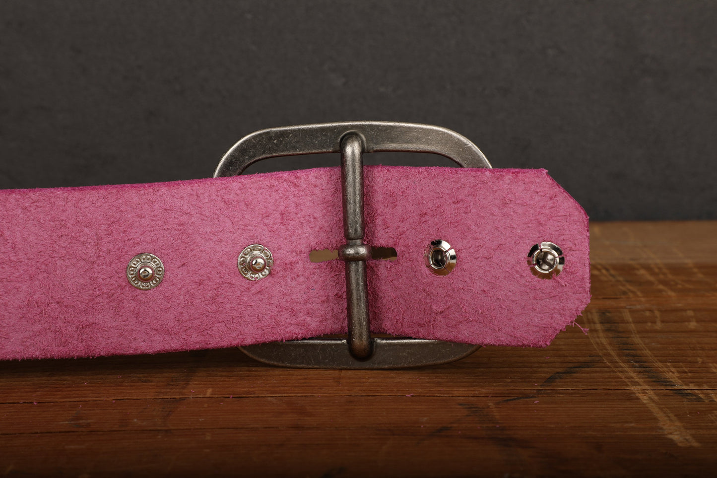 a close up of a pink belt on a wooden surface