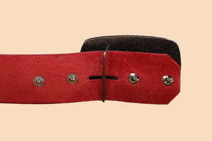a red and black belt with metal buttons